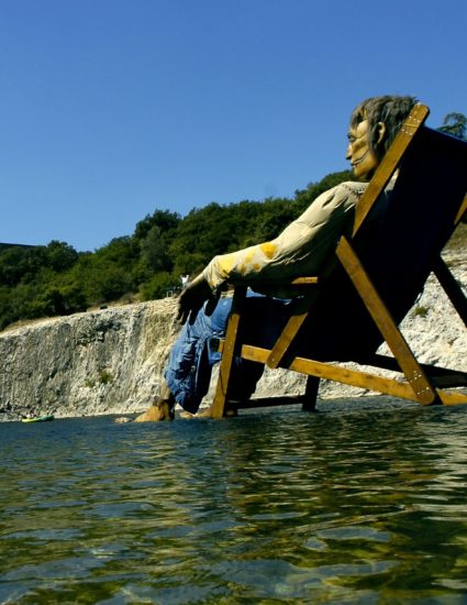 Le Grand Géant dans son transat fait une sieste au milieu de la rivière qui coule sous le pont du Gard