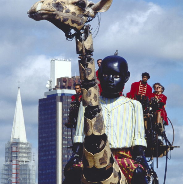 Le Petit Géant est sur le dos de la grande Girafe. Derrière eux la tour de Bretagne, à Nantes
